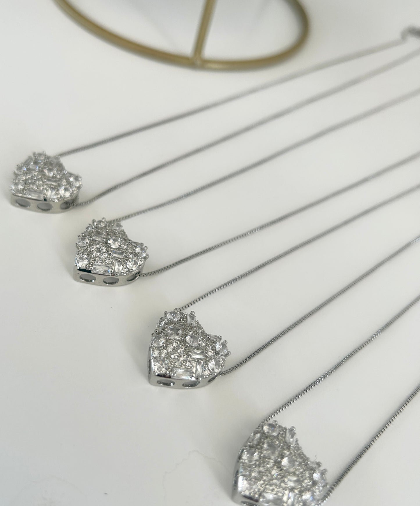 Silver necklaces with heart-shaped diamond pendants on a white background
