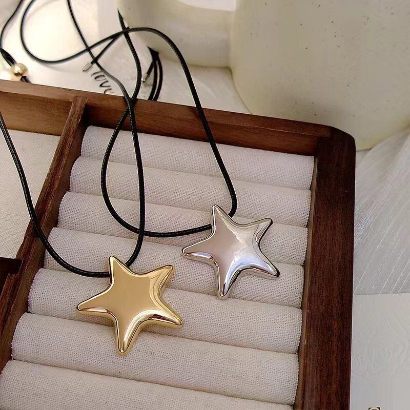 Star-shaped pendants on a wooden stand with a neutral background