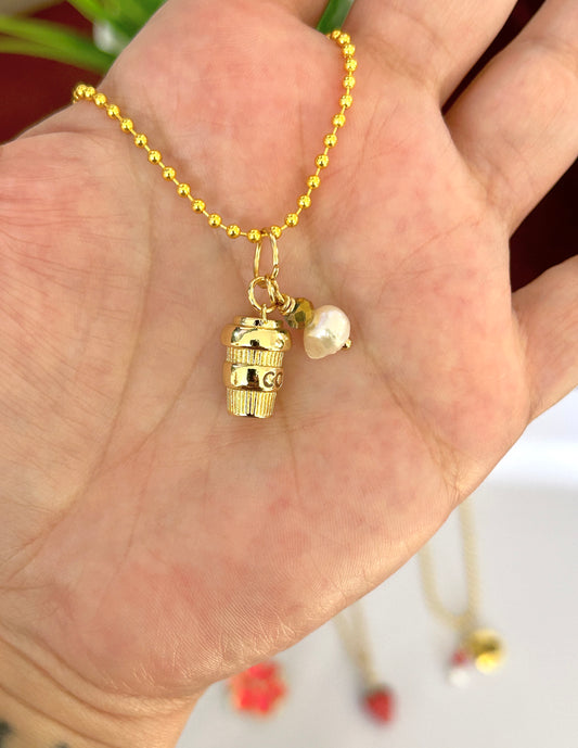 Gold necklace with a pendant and pearl on a hand