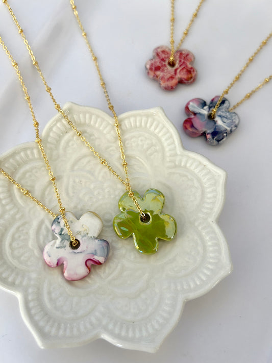 Necklaces with colorful pendant charms on a decorative white dish
