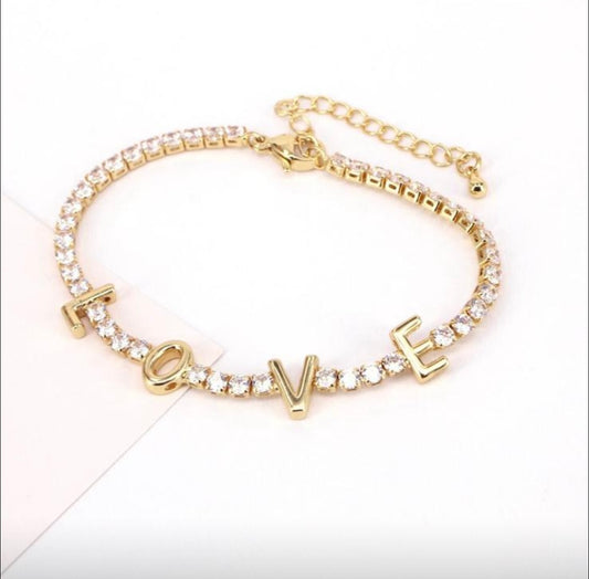 Gold bracelet with 'LOVE' charm on a white background