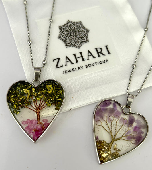 Heart-shaped pendants with nature design on a white background with Zahari Jewelry Boutique packaging.