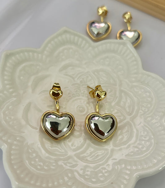 Heart-shaped earrings with gold rims on a decorative white plate