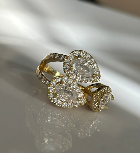 Gold ring with diamond accents on a reflective surface