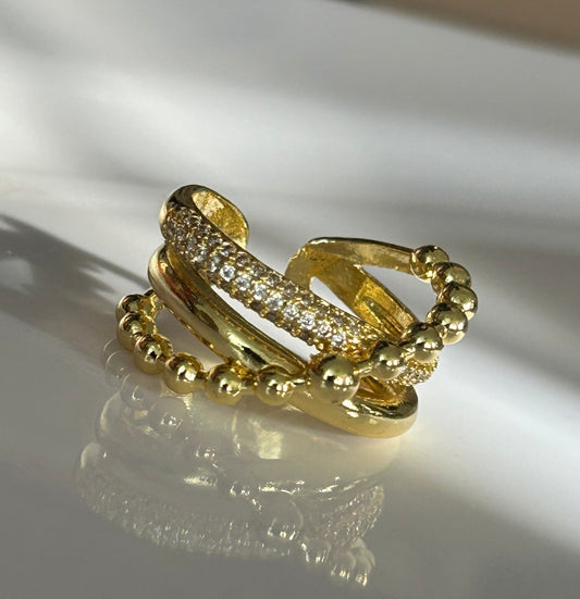Gold ring with diamond accents on a reflective surface