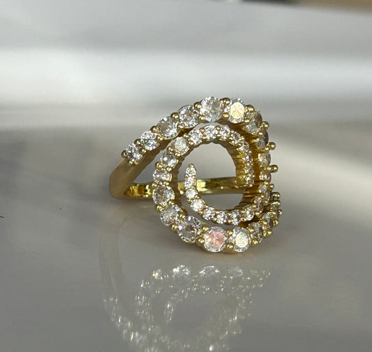 Gold ring with diamond accents on a reflective surface